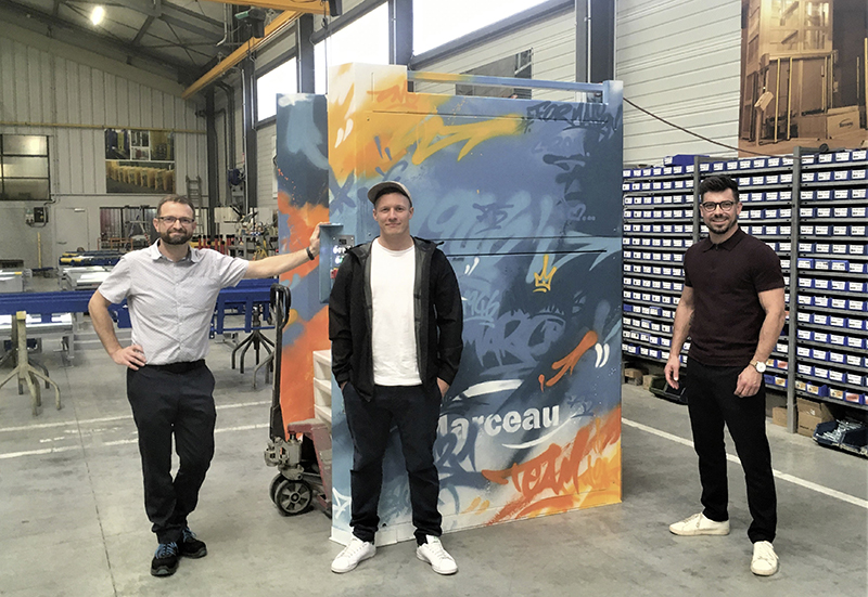 De gauche à droite : Olivier Cuenot, responsable industriel, Benjamin Locatelli, graffeur et Antoine Marceau, chargé d’affaires, devant la machine anniversaire taguée.